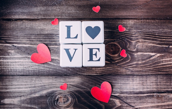 Кубики  с надписью любовь с сердечками на деревянном столе