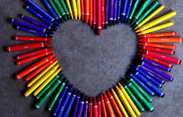 Сердце  из разноцветных карандаш на сером фоне 