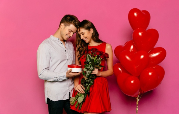 Влюбленная пара с воздушными шариками на розовом фоне 