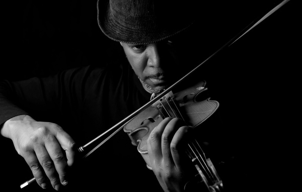 Темнокожий мужчина играет на скрипке 