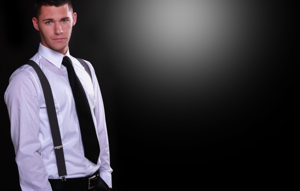 Красивый парень в белой рубашке на черном фоне 