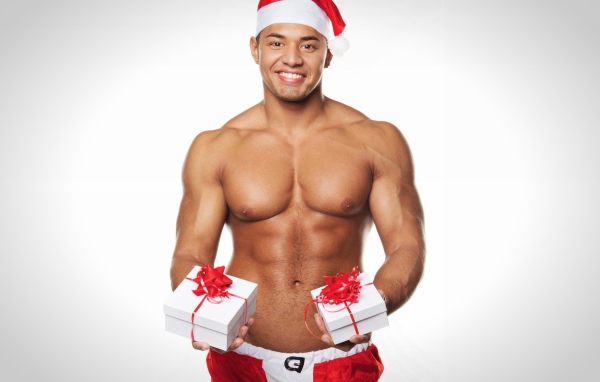 Накаченный мужчина в новогоднем костюме с подарками 
