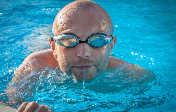 Мужчина пловец в очках в бассейне 