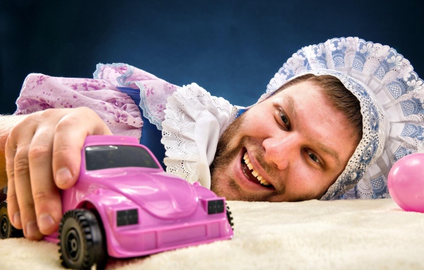 Мужчина в костюме ребенка с машинкой 