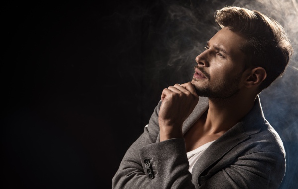 Задумчивый взгляд мужчины на черном фоне 