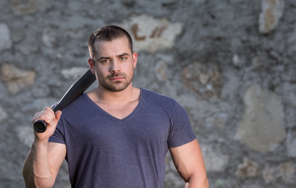 Серьезный парень с бейсбольной битой в руке 