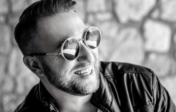 Улыбающийся брутальный мужчина в черных очках