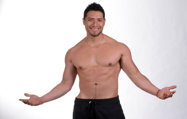 Улыбающийся накаченный мужчина на сером фоне