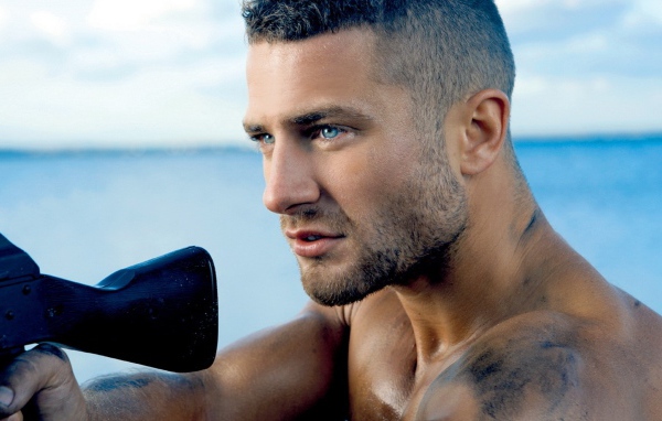 Сильный голубоглазый мужчина с винтовкой в руках 