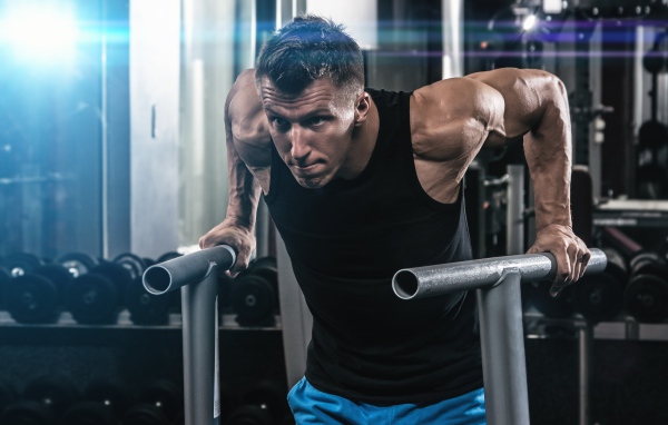 Сильный накаченный мужчина занимается в спортзале 