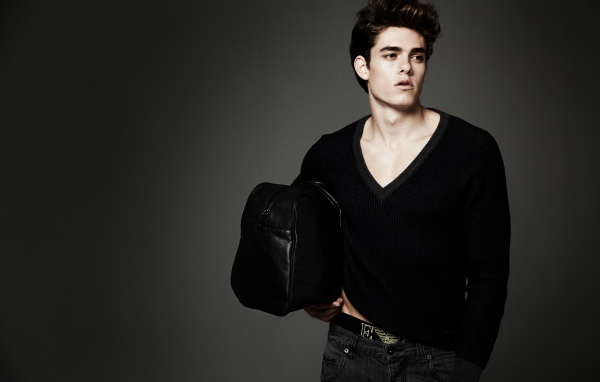 Молодой мужчина с черной сумкой в руке 