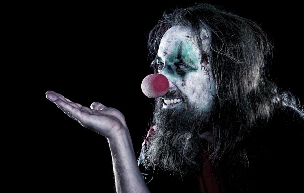 Страшный мужчина клоун на черном фоне 