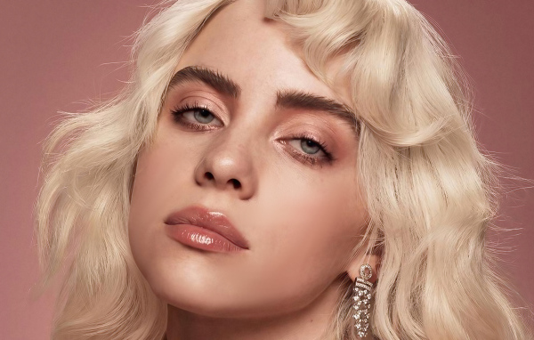 Молодая блондинка Билли Айлиш лицо на розовом фоне