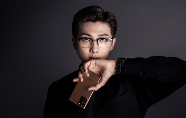 Молодой парень Rm участник группы BTS с телефоном