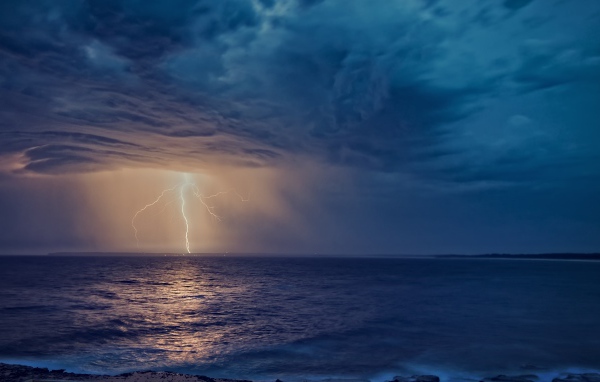 Белая молния рассекает небо в море 