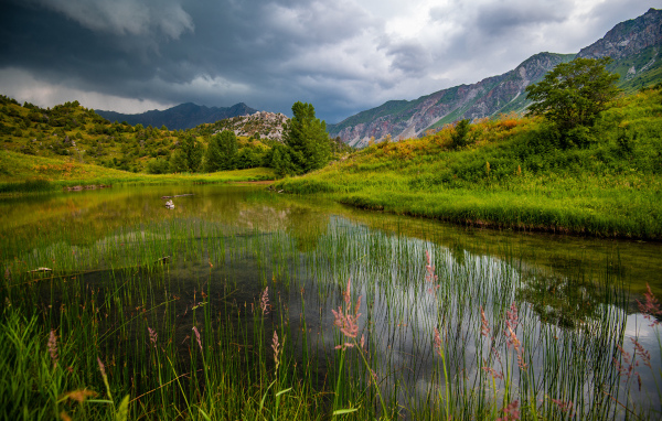 Грозовые облака над рекой в горах 