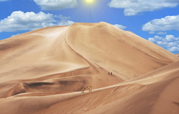 Высокая песчаная дюна под голубым небом 