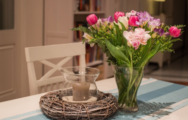 Красивый букет ярких цветов на столе со свечой