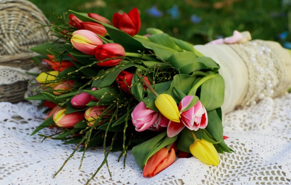 Красивый букет разноцветных тюльпанов на белой шали
