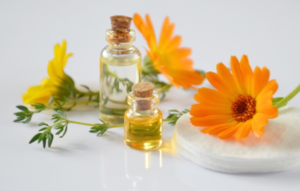 Оранжевые цветы календулы с маслом на столе