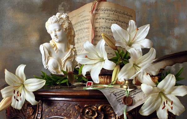Белые лилии, статуя и ноты лежат на столе
