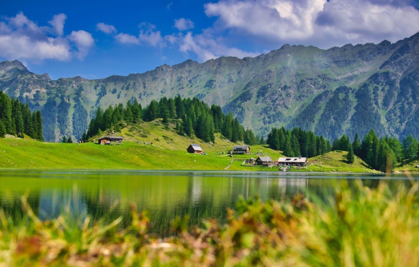 Красивый пейзаж на горы и озеро и зеленые луга