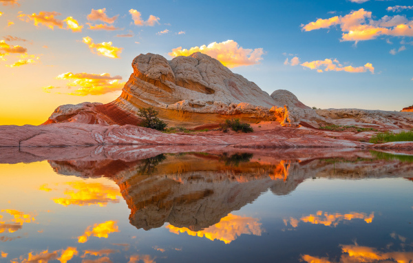 Красивая необычная гора у воды под голубым небом