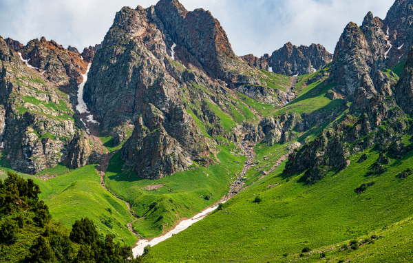 Большие каменные горы с зеленым ковром травы