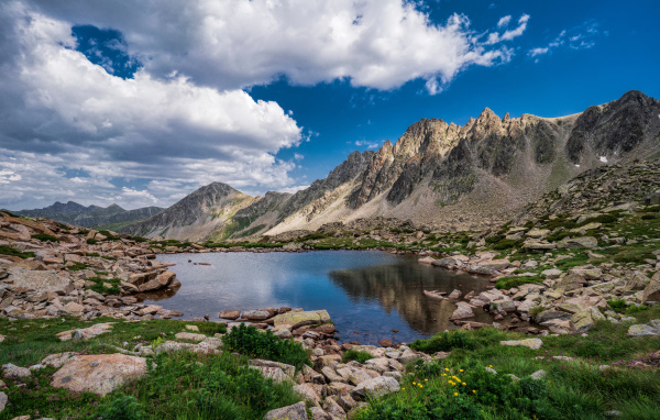 Горы под голубым небом с белыми облаками у озера, Андорра 