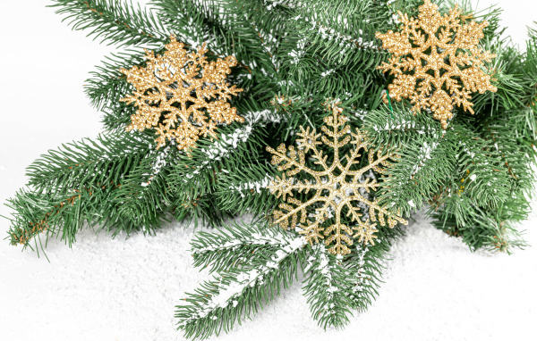 Золотистые снежинки и еловые ветки на снегу