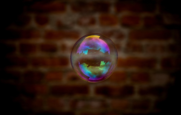 Мыльный пузырь в воздухе на фоне стены