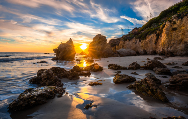 Яркий рассвет летнего солнца над скалами и океана