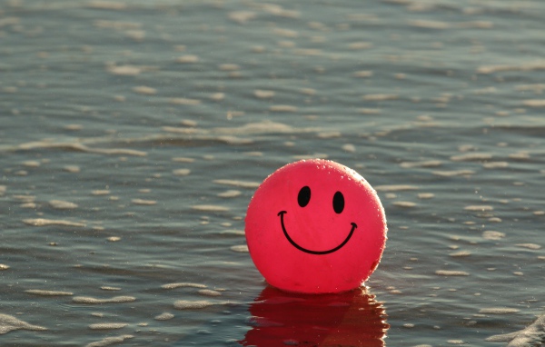 Красный мяч смайлик в воде 