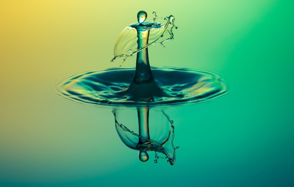 След от капли воды отражается в голубой поверхности 