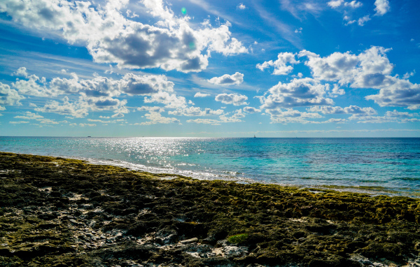 Яркое голубое небо с белыми облаками над морем