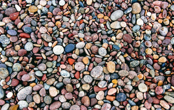 Мелкие разноцветные камни на морском берегу 