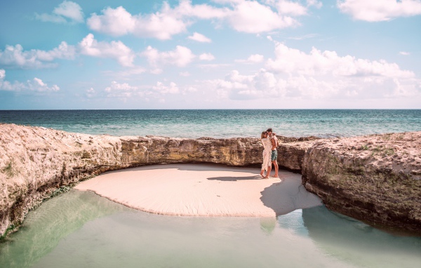 Каменное ограждение на морском пляже летом 