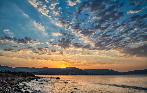 Рассвет солнца за горой у озера 