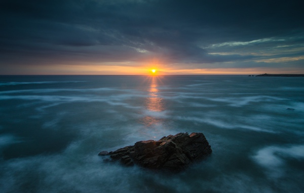 Закат солнца над покрытом льдом озером 