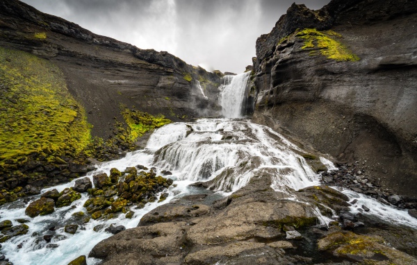 Быстрый горный водопад под серым небом