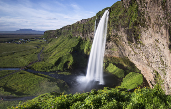 Быстрый водопад Сельяландсфосс стекает со скалы, Исландия