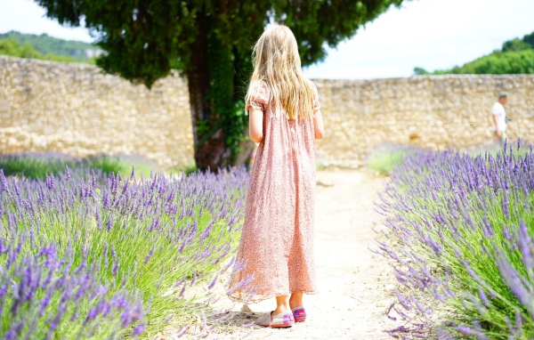Little girl in a dress on the field with lavender