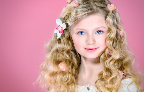 Красивая голубоглазая девочка блондинка на розовом фоне