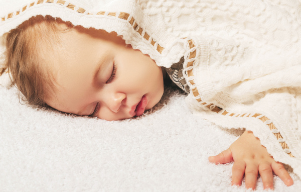 Милый спящий ребенок под покрывалом 