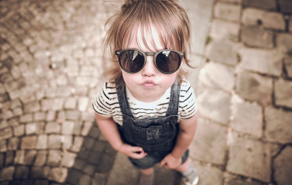 Модная маленькая девочка в черных очках