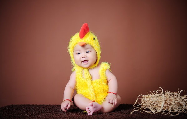 Маленький мальчик азиат в костюме цыпленка