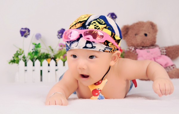 Маленький ребенок азиат в шапке с очками