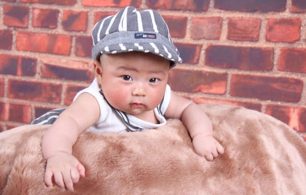 Маленький азиатский ребенок на фоне стены