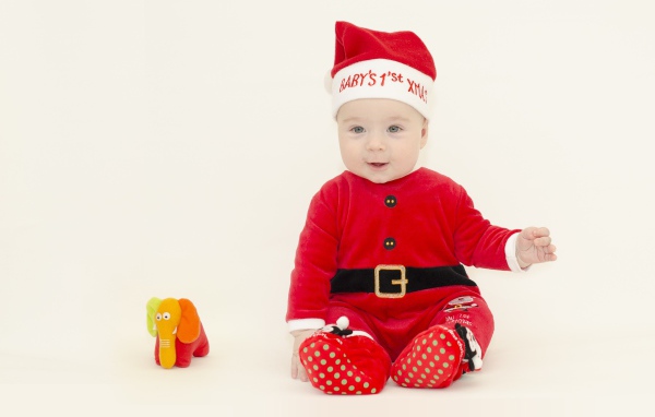 Маленький мальчик в новогоднем костюме на белом фоне