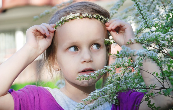 Маленькая девочка украсила голову белым цветком 